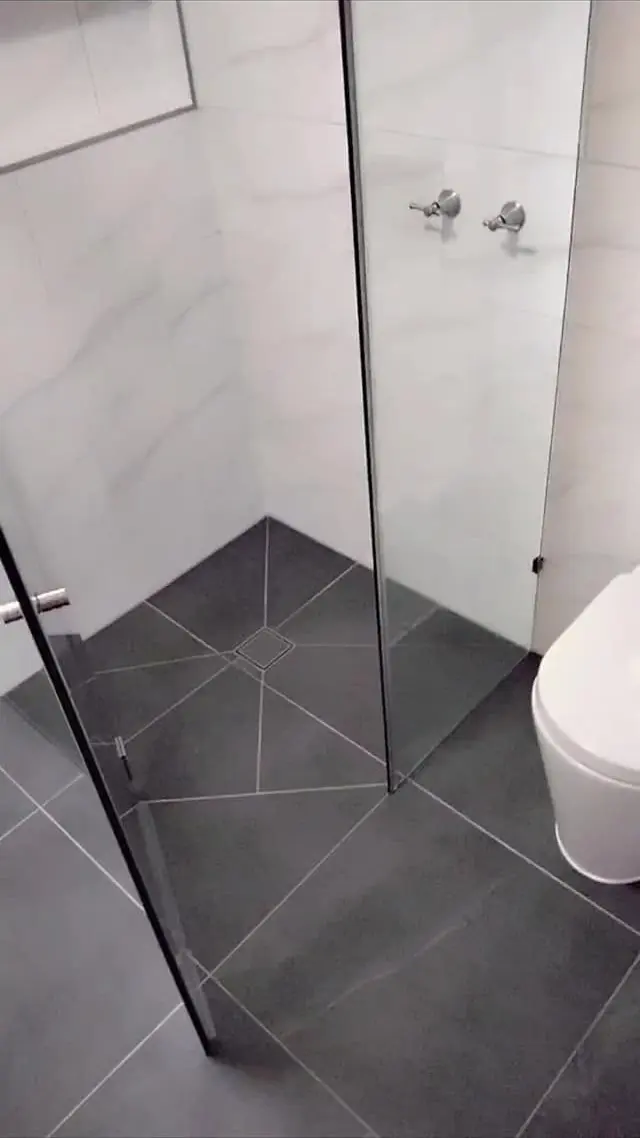 Ensuite with large white wall tiles and dark floor tiles