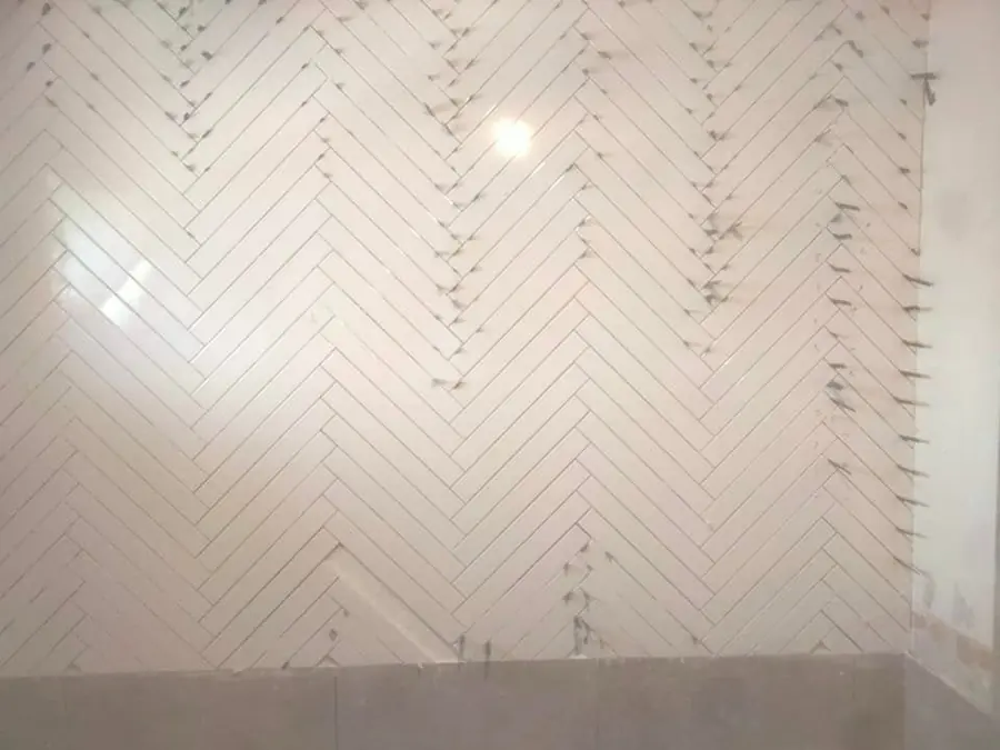 White herringbone feature wall mid-install