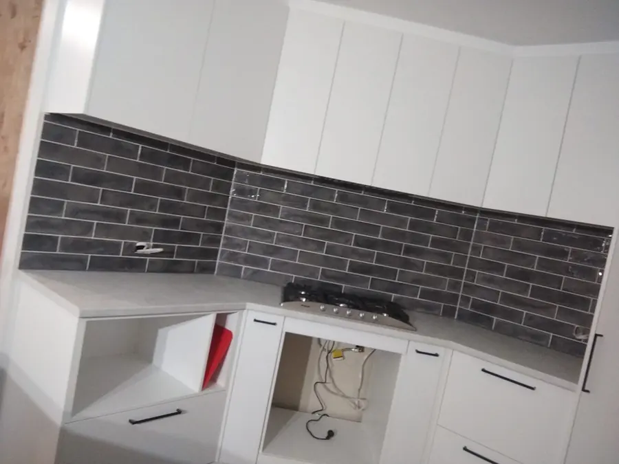 Charcoal subway tile kitchen splashback under white cabinetry