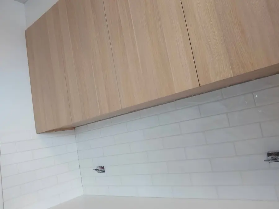 White gloss subway splashback under timber cabinetry