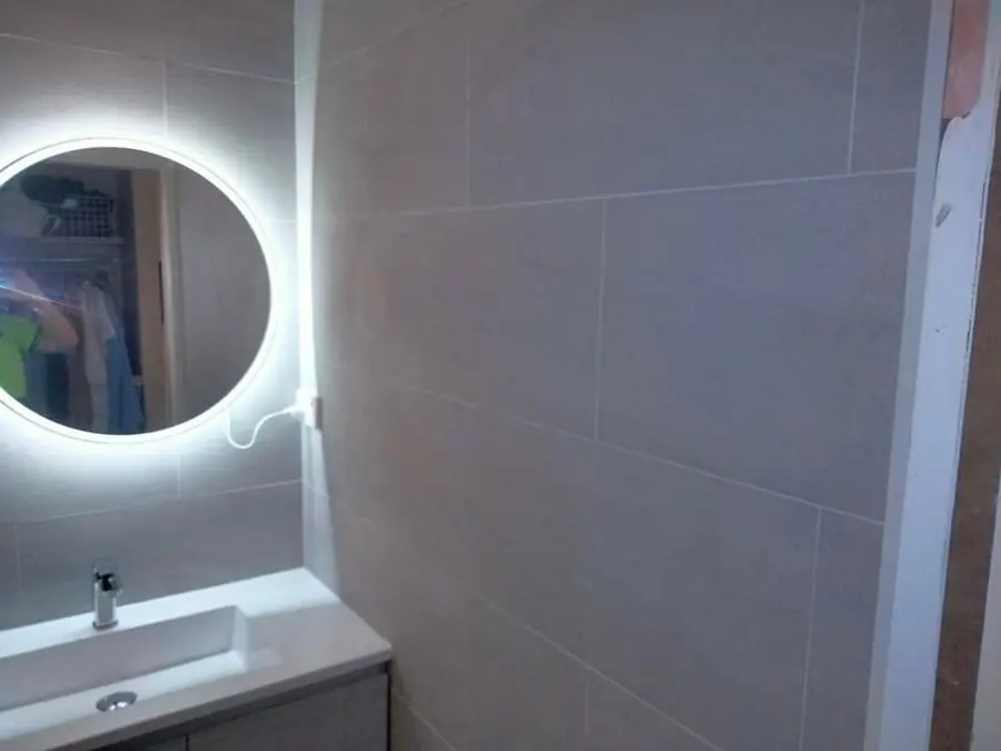 Vanity with LED mirror and large format grey wall tiles